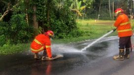 Photo: petugas Damkartan Karangasem membersihkan tumpahan solar di jalan raya di wilayah Besang (dok: Damkartan Karangasem)