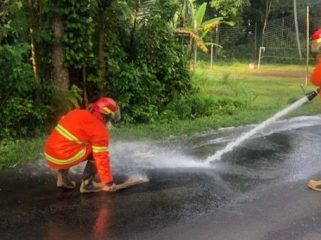 Photo: petugas Damkartan Karangasem membersihkan tumpahan solar di jalan raya di wilayah Besang (dok: Damkartan Karangasem)