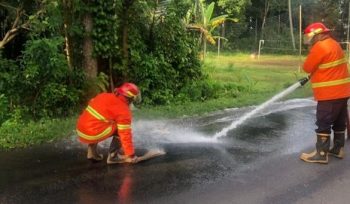 Photo: petugas Damkartan Karangasem membersihkan tumpahan solar di jalan raya di wilayah Besang (dok: Damkartan Karangasem)