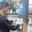 Salah seorang pegawai Perumdam Tirta Berkah yang sedang memasang stiker promo perumdam